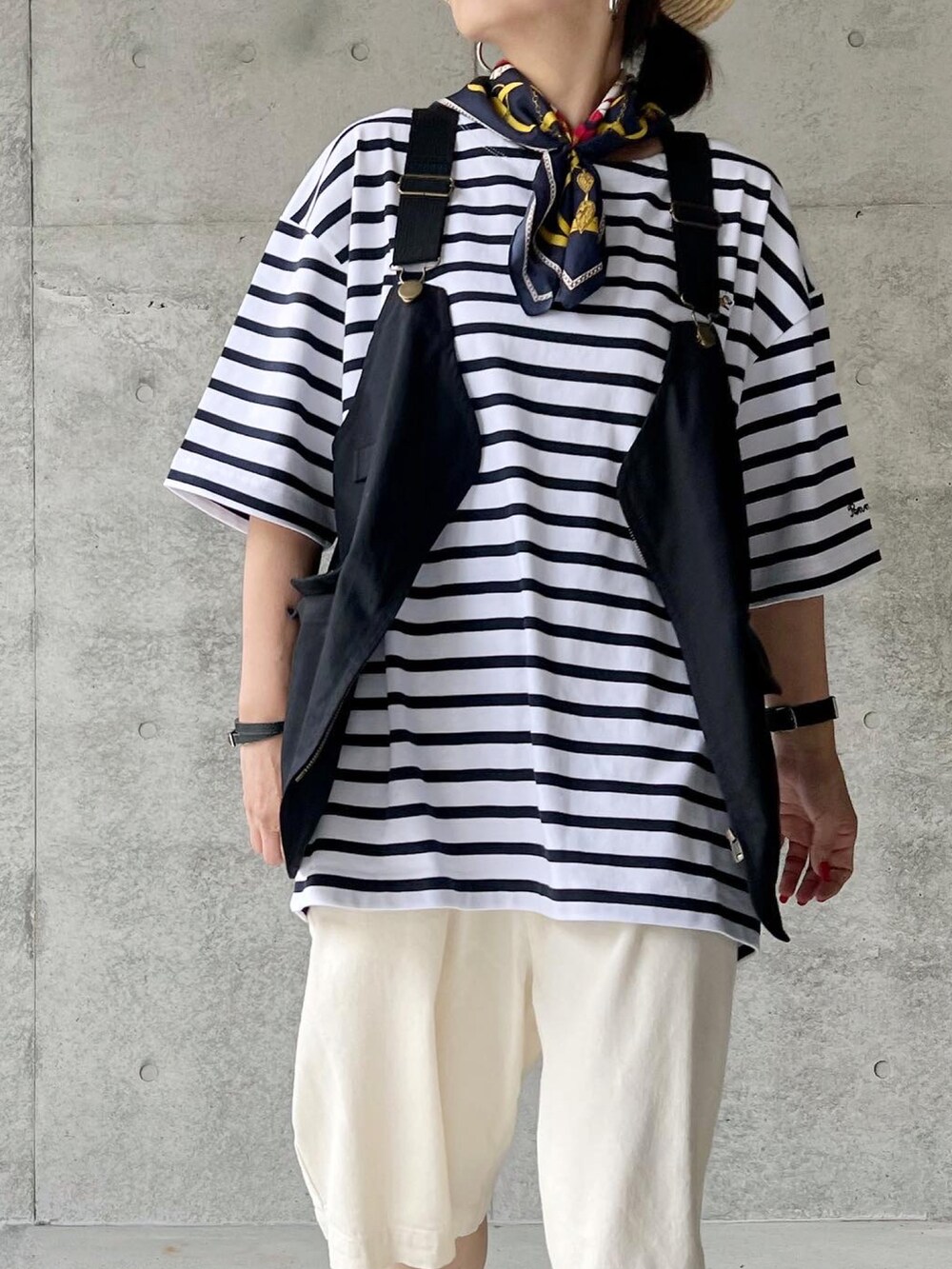 ホワイト系のTシャツ/カットソー、ブラック系のベスト、ホワイト系のパンツを着用したレディースの春コーディネートの2枚目の写真
