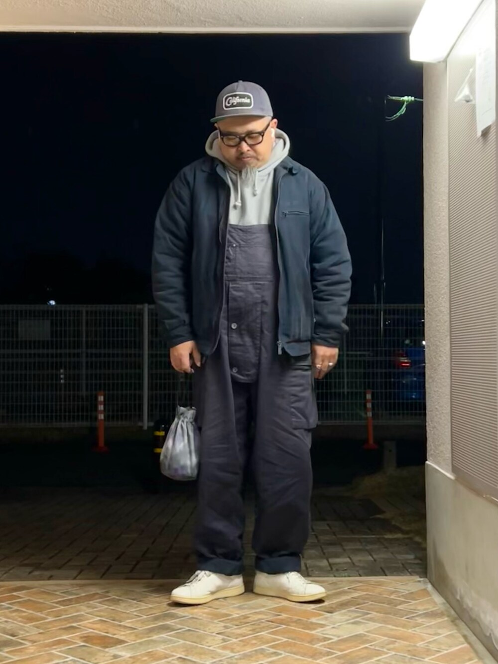 ホワイト系のスニーカー、ブルー系のその他パンツ、その他のバッグを着用したメンズの冬コーディネートの2枚目の写真