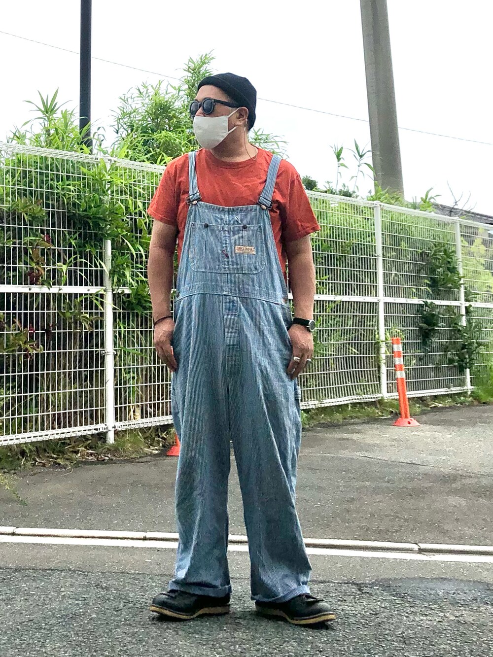 ブラック系のブーツ、その他のサロペット/オーバーオール、オレンジ系のTシャツ/カットソーを着用したメンズの秋コーディネートの2枚目の写真