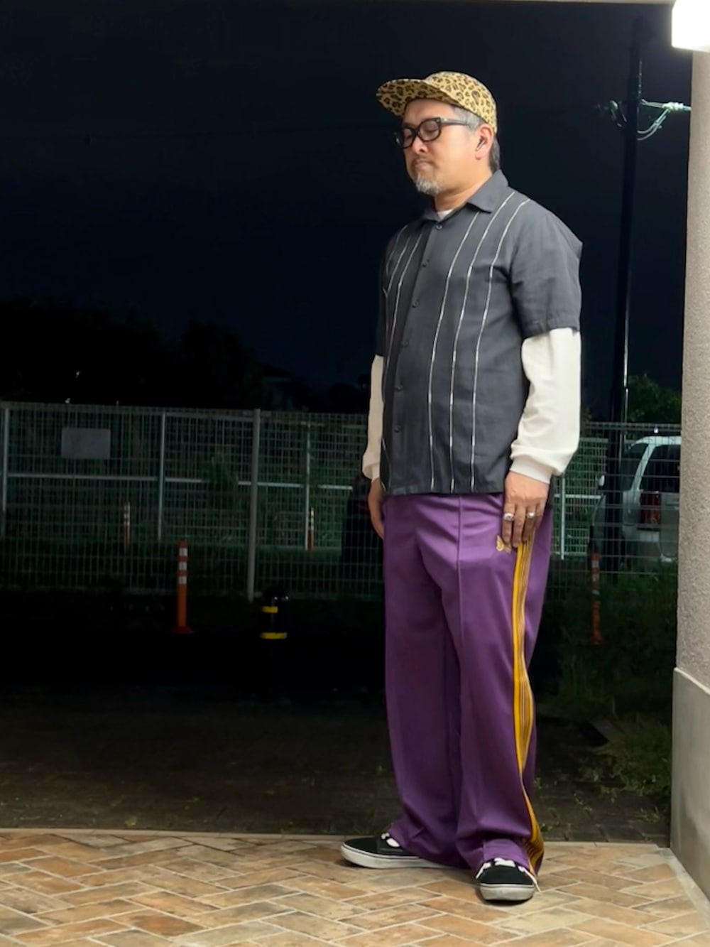 パープル系のその他パンツ、ブラック系のスニーカー、ブラック系のシャツ/ブラウスを着用したメンズの春コーディネートの2枚目の写真