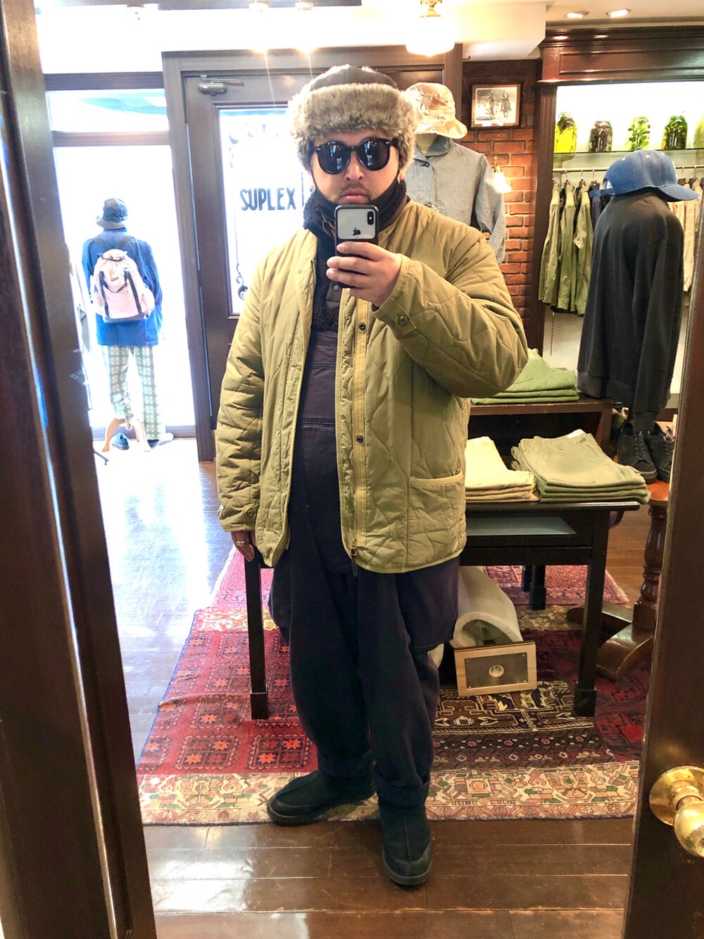 グリーン系のブルゾン、ブルー系のその他パンツ、ブラック系のブーツを着用したメンズの冬コーディネートの3枚目の写真