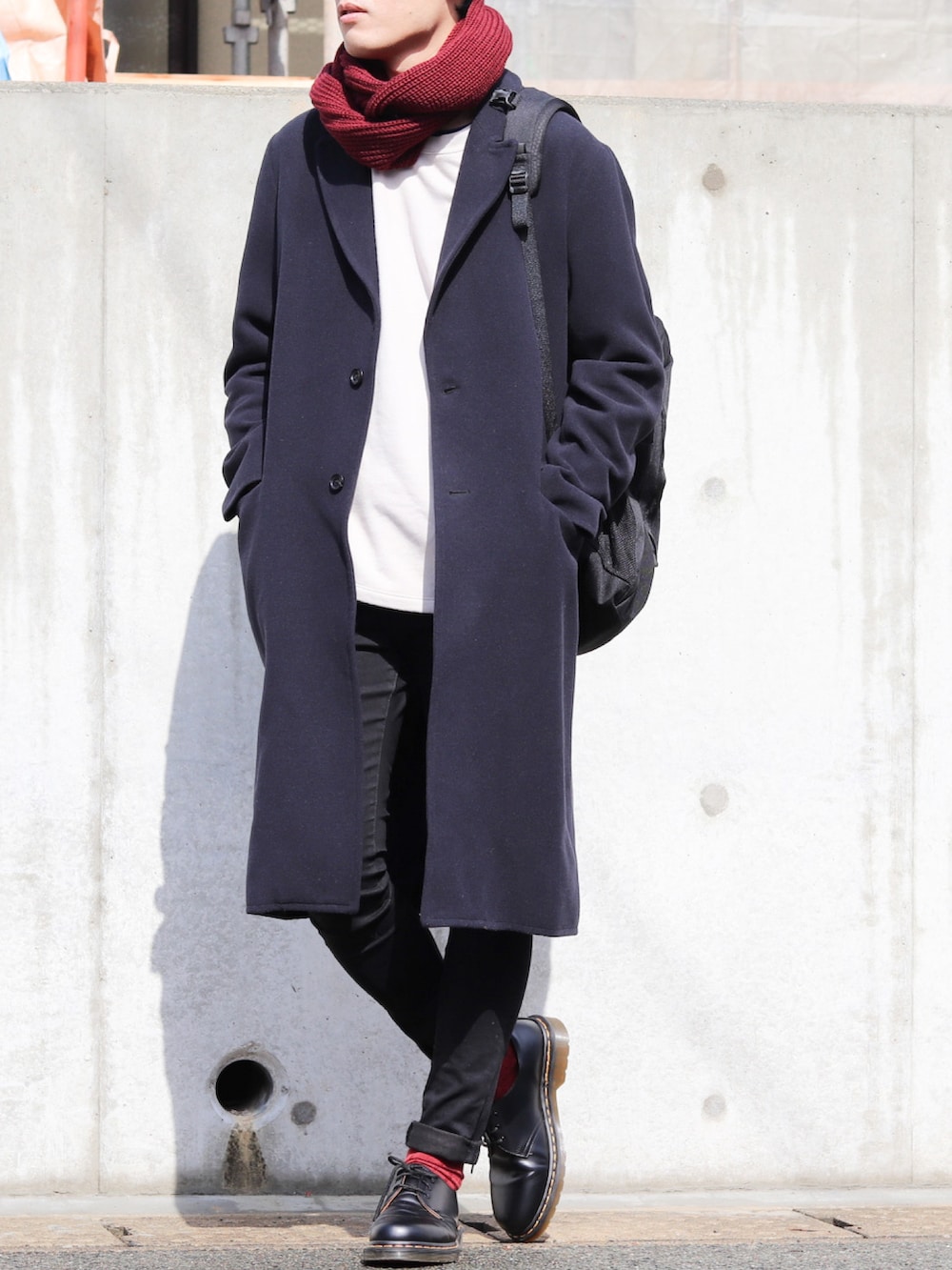 ブルー系のチェスターコート、グレー系のスウェット、ブラック系のバックパック/リュックを着用したメンズの秋コーディネートの2枚目の写真