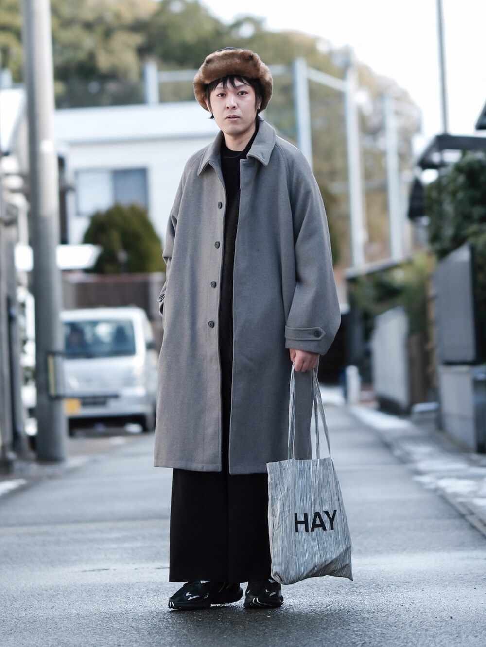 ブラウン系のニット/セーター、ベージュ系のステンカラーコート、ブラック系のその他パンツを着用したメンズの冬コーディネートの3枚目の写真