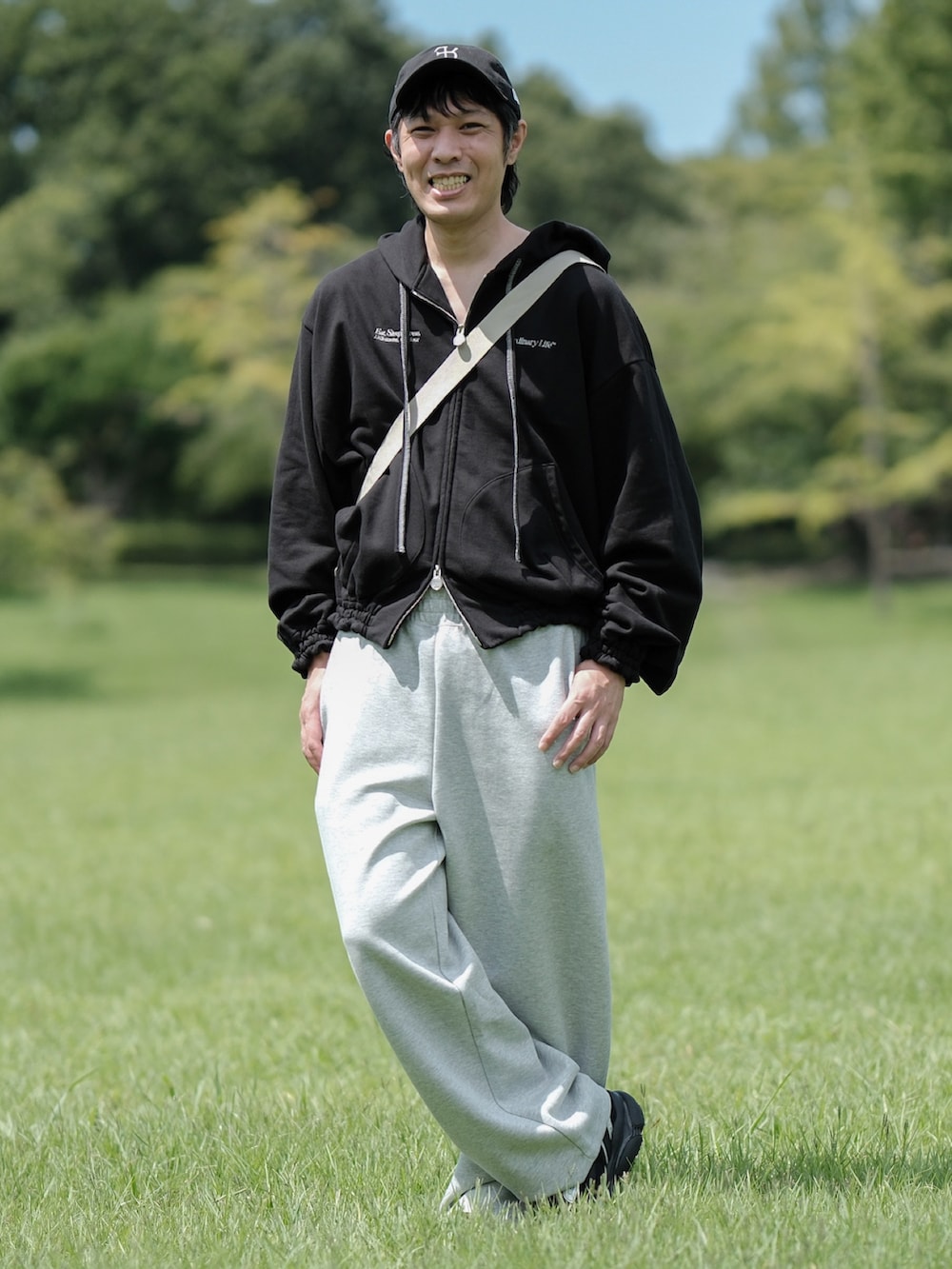 ブラック系のスニーカー、ブラック系のパーカー、グレー系のスウェットパンツを着用したメンズの夏コーディネートの2枚目の写真