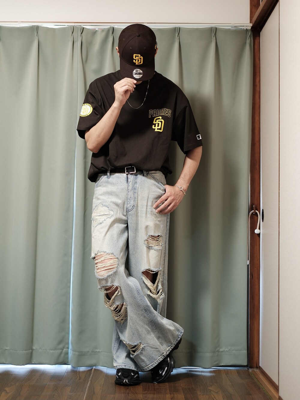 ブラウン系のTシャツ/カットソー、ブルー系のデニムパンツ、ブラック系のスニーカーを着用したメンズの夏コーディネートの3枚目の写真