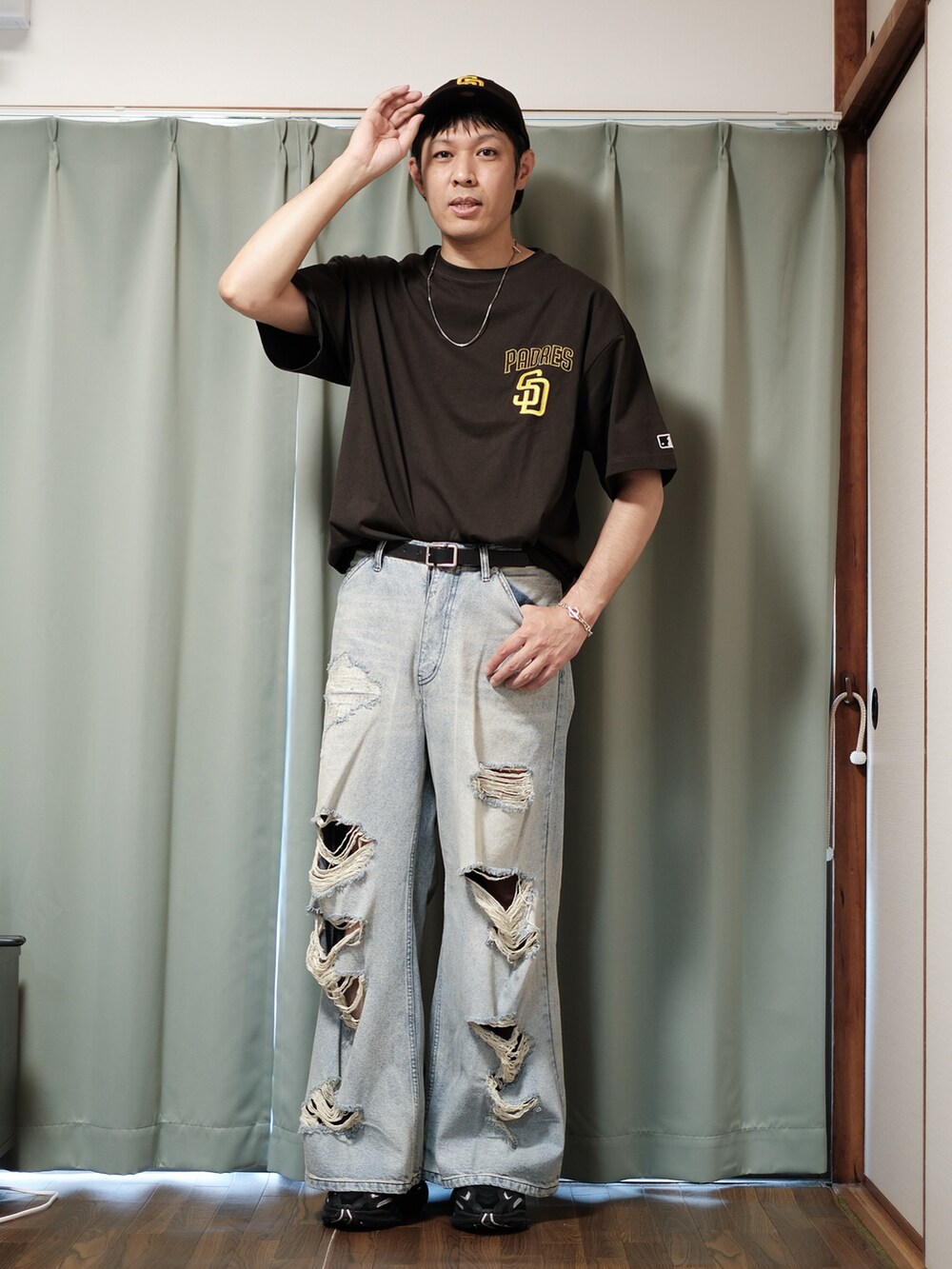 ブラウン系のTシャツ/カットソー、ブルー系のデニムパンツ、ブラック系のスニーカーを着用したメンズの夏コーディネートの2枚目の写真