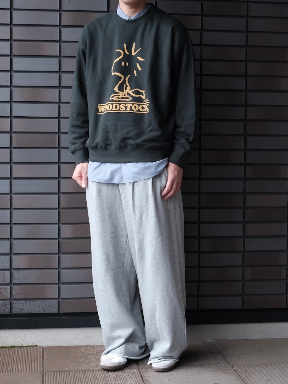 グリーン系のスウェット、グレー系のスウェットパンツ、ホワイト系のスニーカーを着用したメンズの秋コーディネートの2枚目の写真