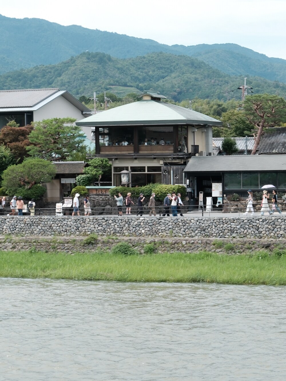 ブルー系のTシャツ/カットソー、ブラック系のショルダーバッグ、ブルー系のデニムパンツを着用したメンズの夏コーディネートの4枚目の写真