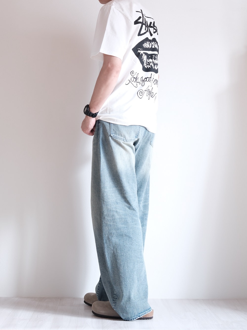 ベージュ系のサンダル、ブルー系のデニムパンツ、ホワイト系のTシャツ/カットソーを着用したメンズの夏コーディネートの2枚目の写真