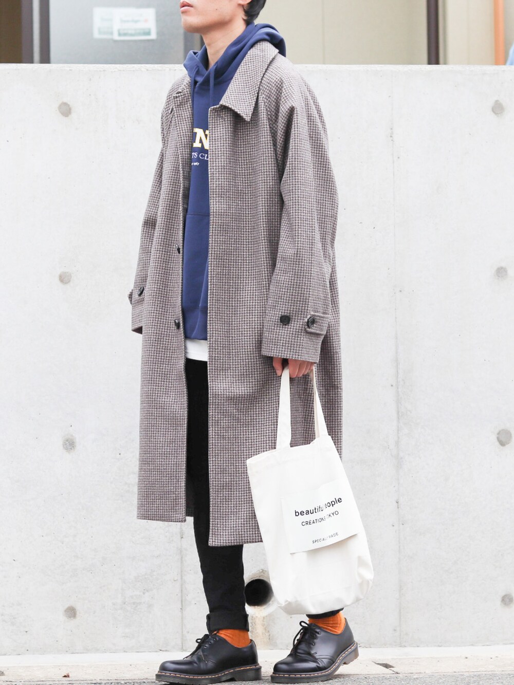 ブルー系のパーカー、ブラウン系のステンカラーコート、ホワイト系のタンクトップを着用したメンズの冬コーディネートの2枚目の写真