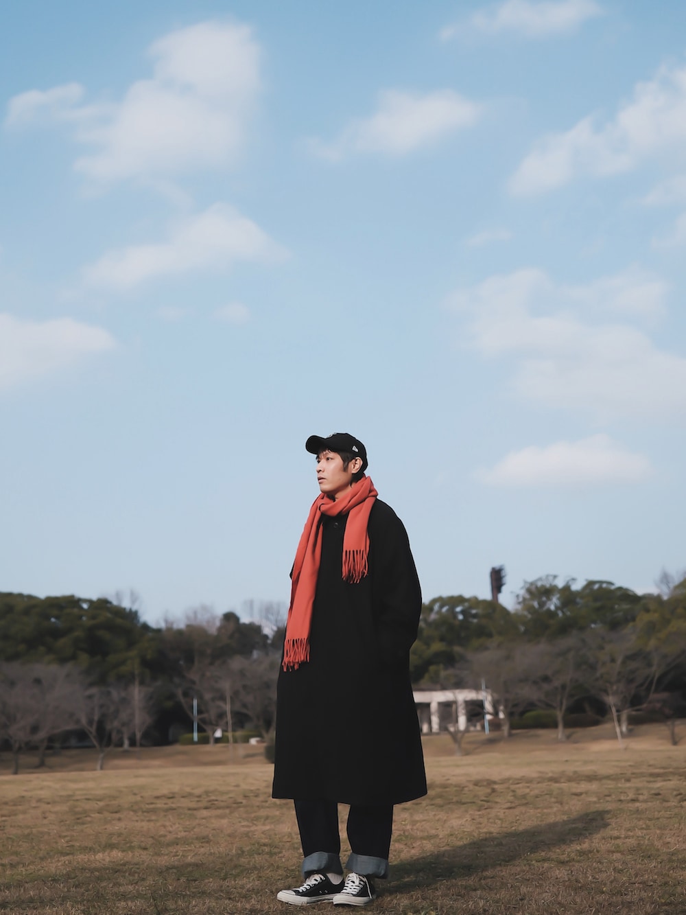 ブラック系のステンカラーコート、ブルー系のその他パンツ、ブラック系のスニーカーを着用したメンズの冬コーディネートの2枚目の写真