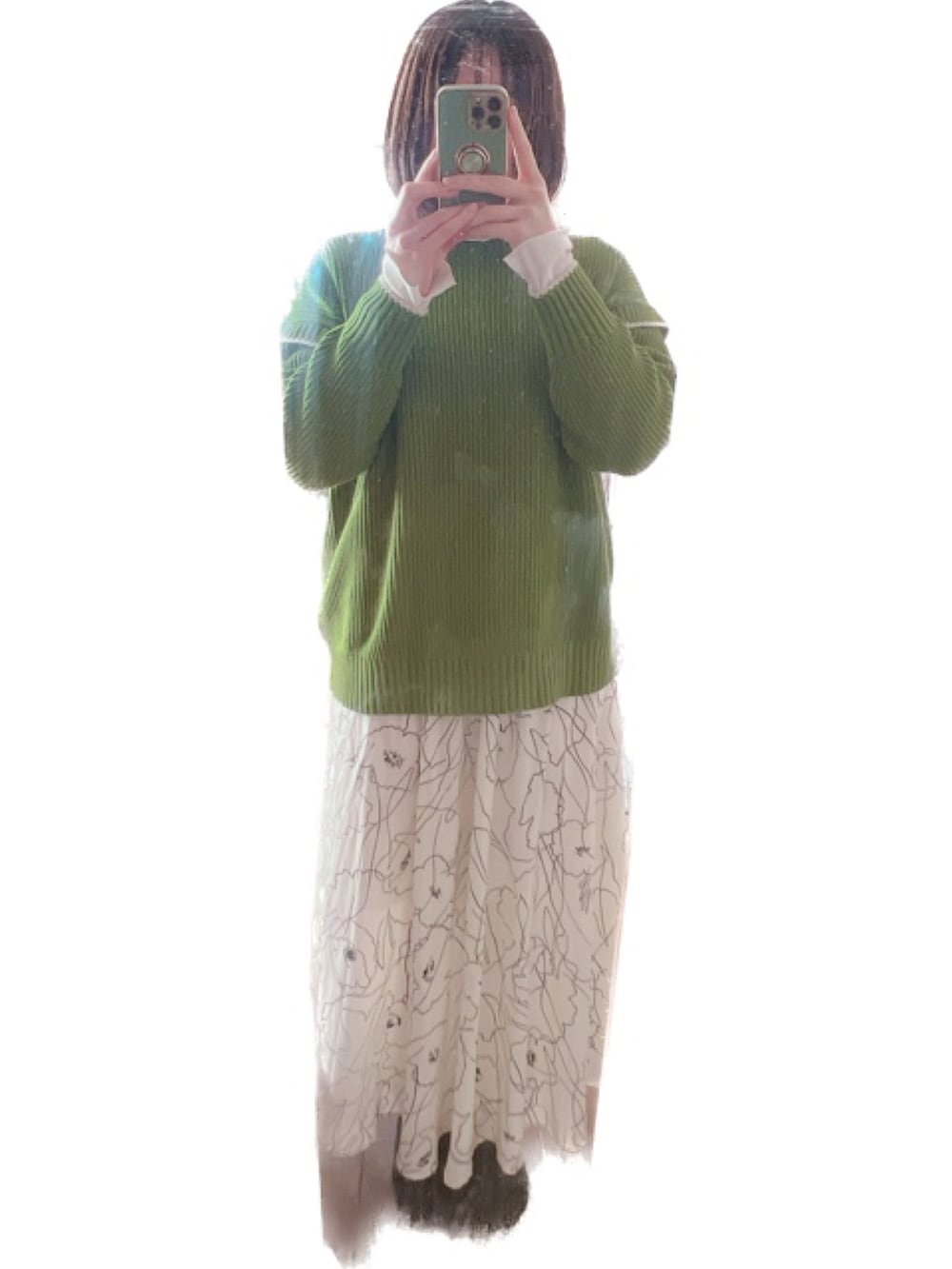 グレー系のベスト、グリーン系のニット/セーター、ホワイト系のスカートを着用したレディースの春コーディネートの2枚目の写真