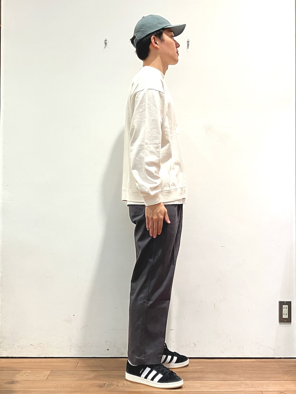 グリーン系のジャケット/アウター、ベージュ系のTシャツ/カットソー、ブラック系のスニーカーを着用したメンズの秋コーディネートの5枚目の写真