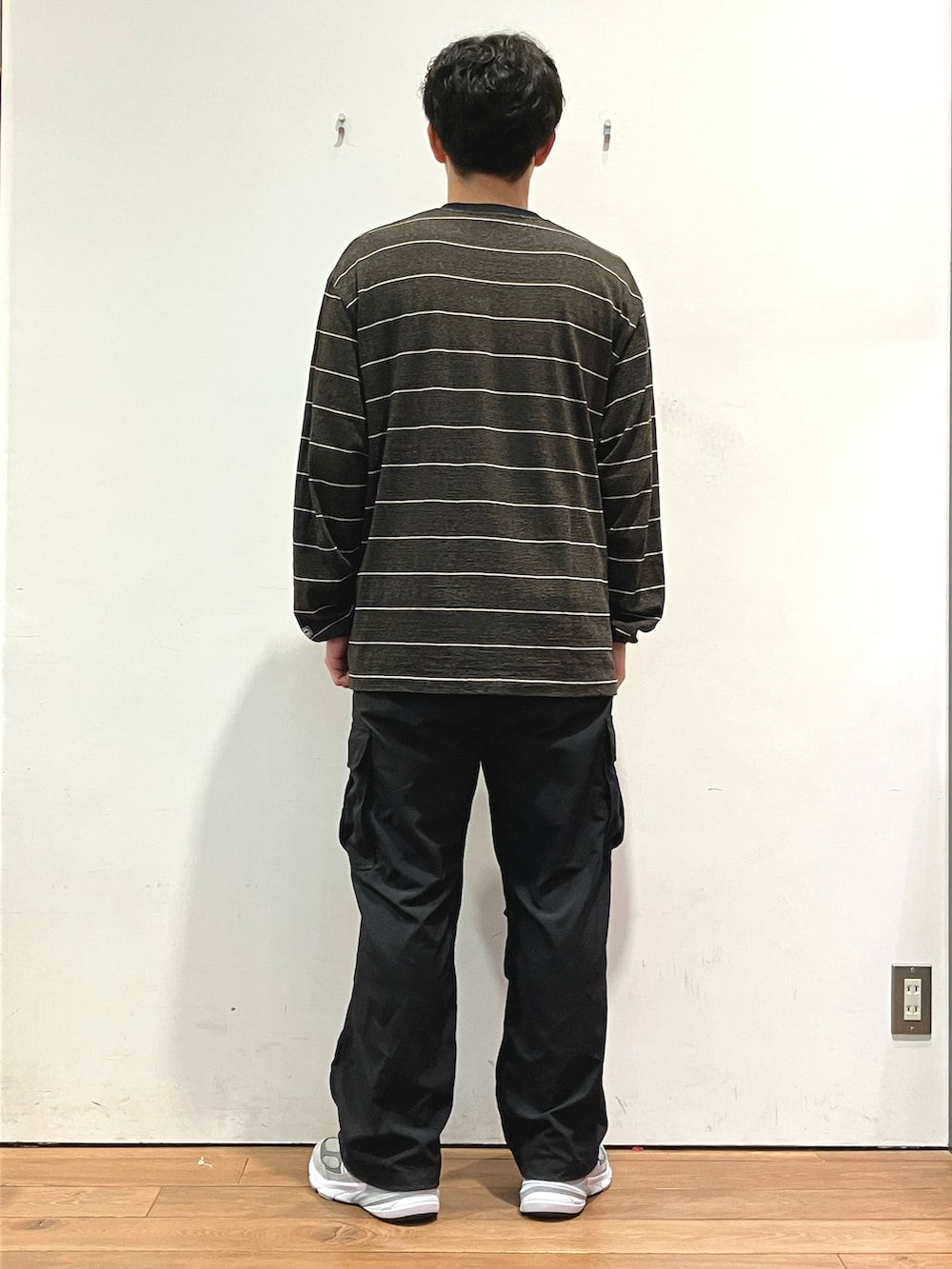 ブラック系のTシャツ/カットソー、ブラック系のカーゴパンツ、グレー系のスニーカーを着用したメンズの秋コーディネートの3枚目の写真