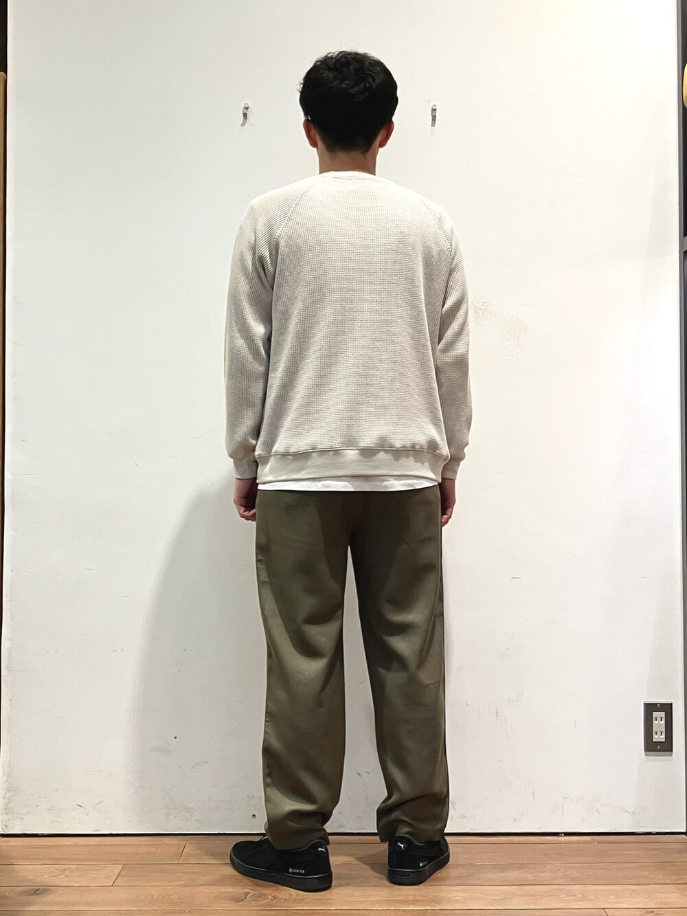 ブラック系のその他アウター、ベージュ系のTシャツ/カットソー、グレー系のその他パンツを着用したメンズの冬コーディネートの6枚目の写真