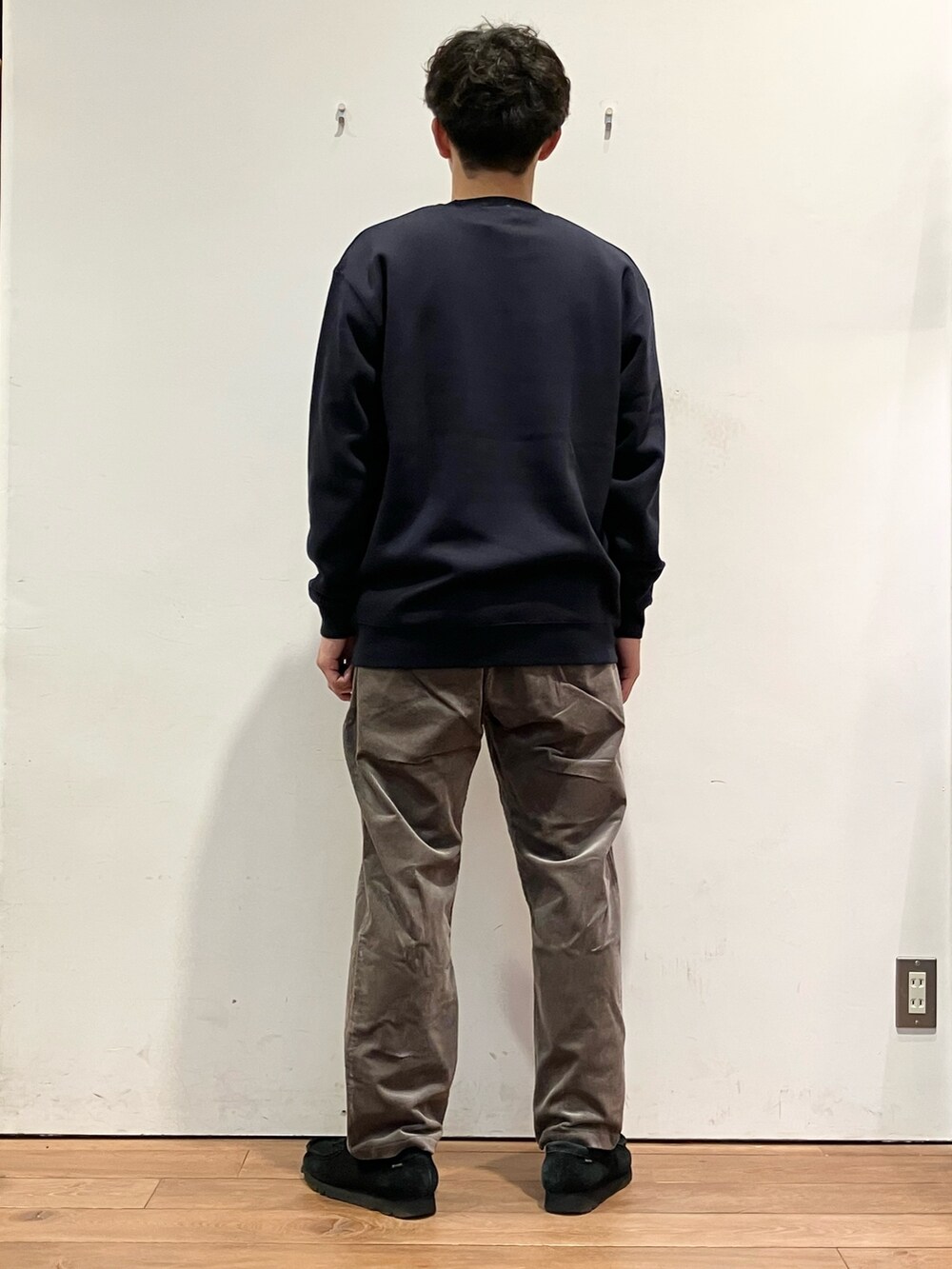 ベージュ系のベスト、ブルー系のスウェット、ブラウン系のパンツを着用したメンズの秋コーディネートの6枚目の写真