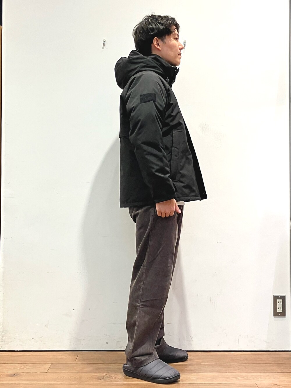 ブラック系のダウンジャケット/コート、ホワイト系のスウェット、ブラウン系のその他パンツを着用したメンズの秋コーディネートの2枚目の写真