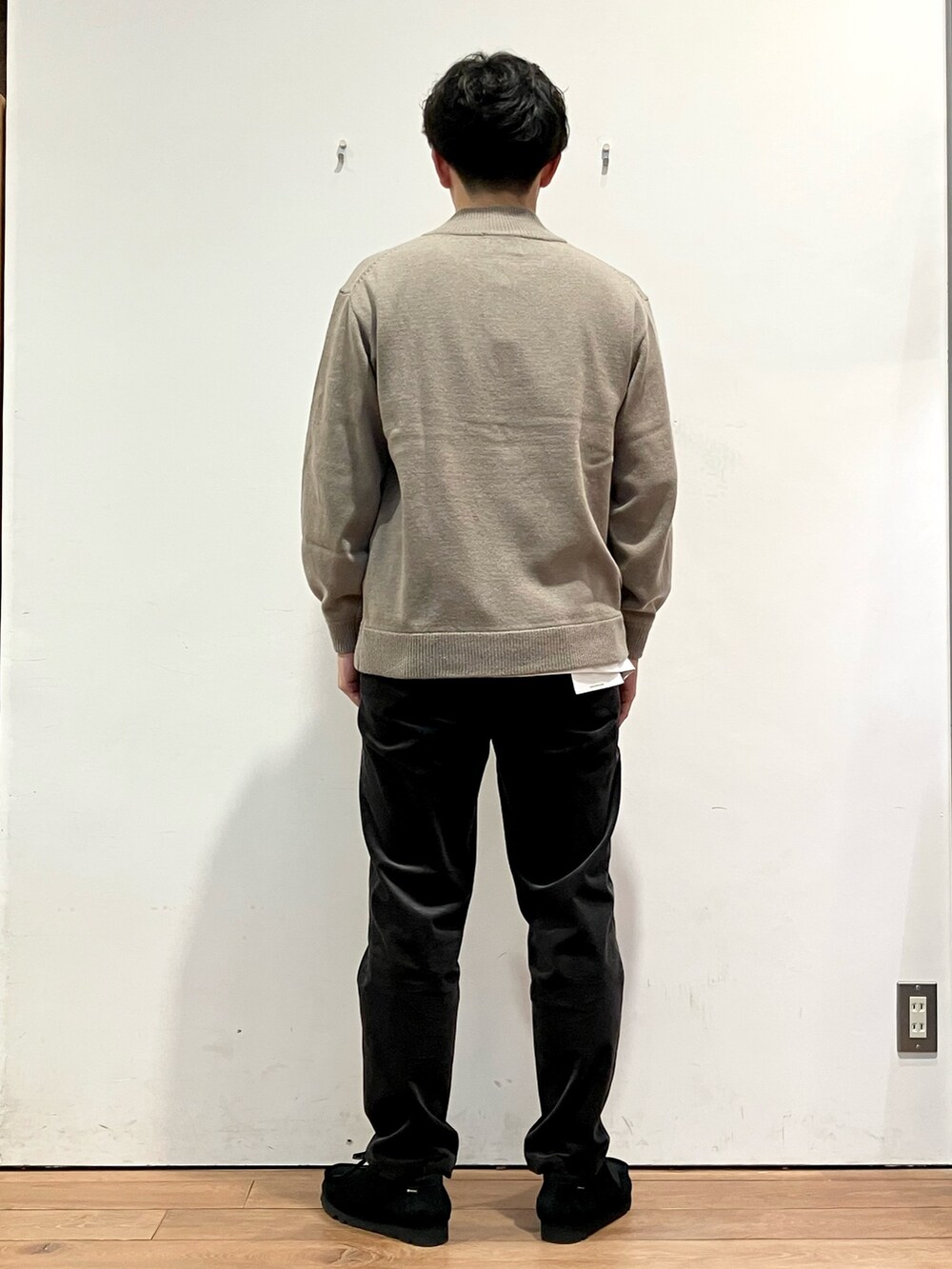 ホワイト系のダウンジャケット/コート、グレー系のその他パンツ、ブラック系のモカシン/デッキシューズを着用したメンズの秋コーディネートの6枚目の写真