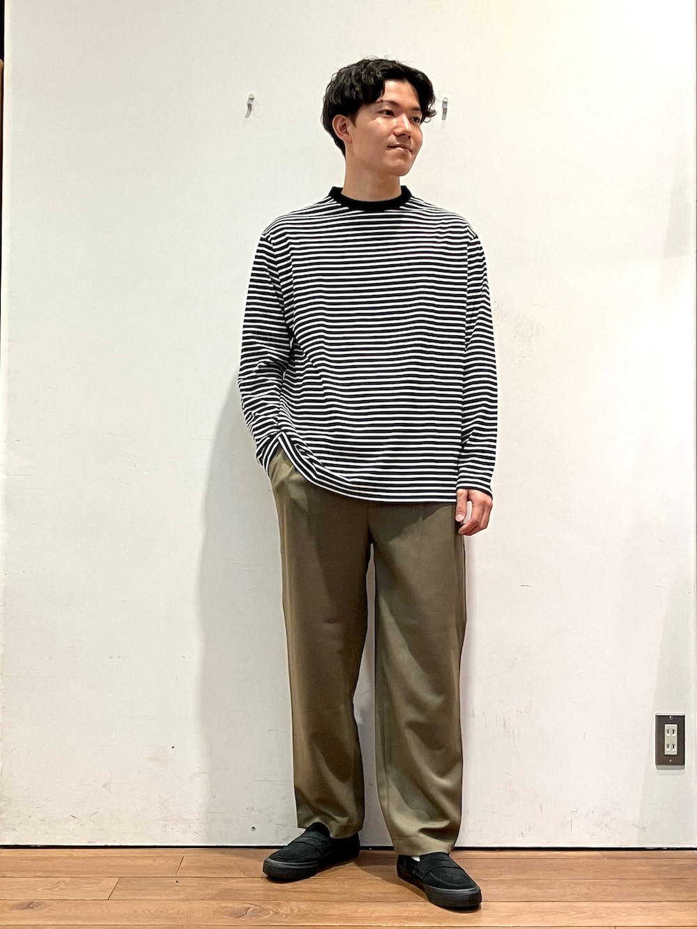 グレー系のカーディガン/ボレロ、ホワイト系のTシャツ/カットソー、グリーン系のパンツを着用したメンズの秋コーディネートの4枚目の写真