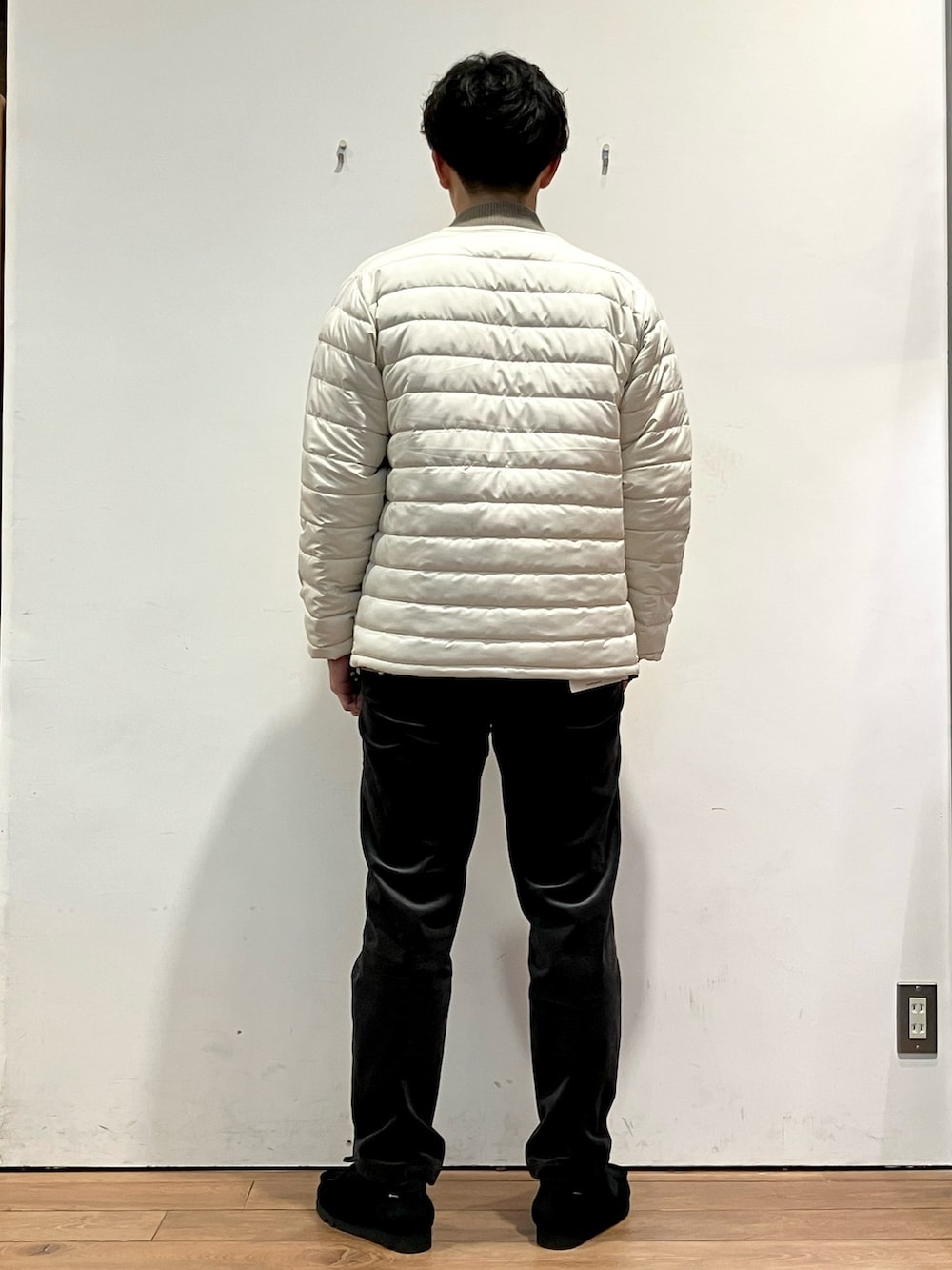 ホワイト系のダウンジャケット/コート、グレー系のその他パンツ、ブラック系のモカシン/デッキシューズを着用したメンズの秋コーディネートの3枚目の写真