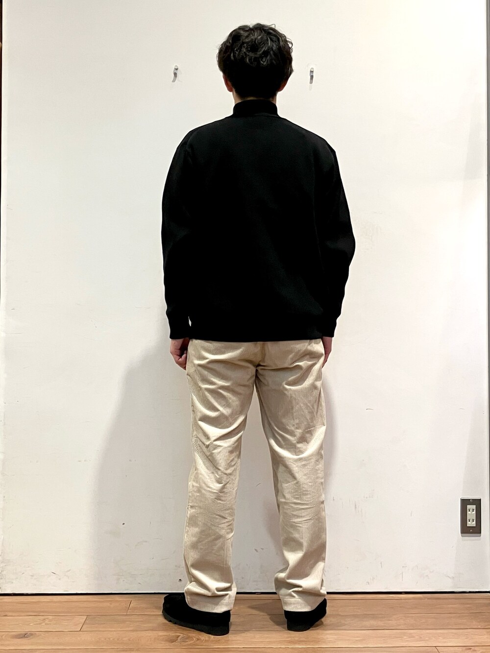 ブラウン系のその他アウター、ブラック系のニット/セーター、ホワイト系のその他パンツを着用したメンズの秋コーディネートの6枚目の写真