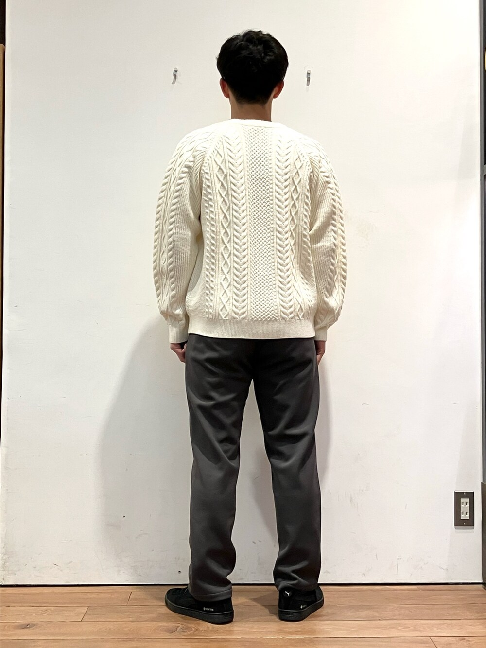 ブラウン系のその他アウター、ホワイト系のニット/セーター、ベージュ系のその他パンツを着用したメンズの冬コーディネートの7枚目の写真