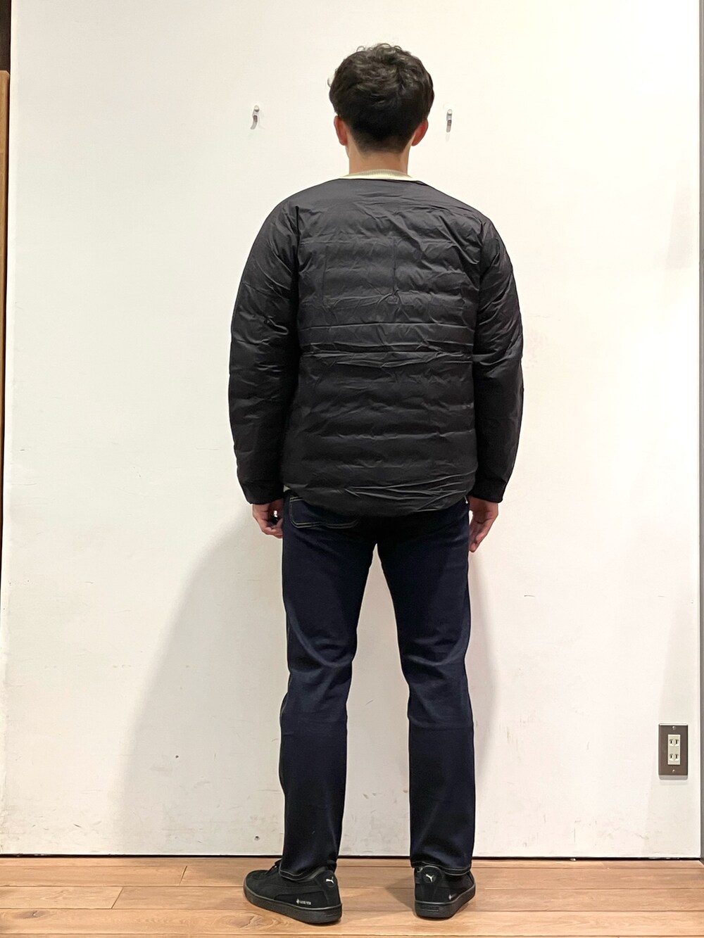 ホワイト系のニット/セーター、ブラック系のダウンジャケット/コート、ブルー系のその他パンツを着用したメンズの冬コーディネートの4枚目の写真