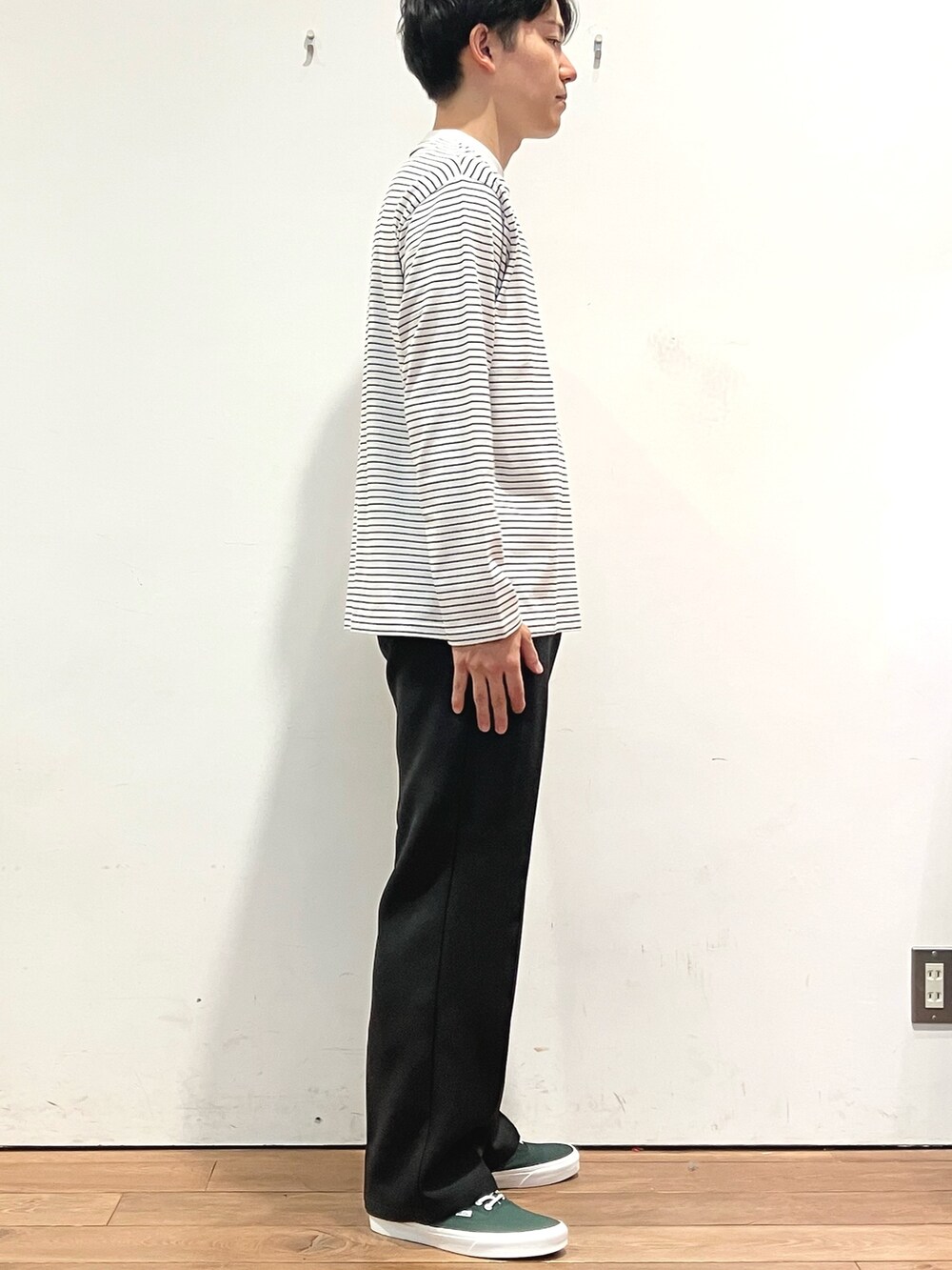 ブラウン系のカーディガン/ボレロ、ブラック系のTシャツ/カットソー、グリーン系のスニーカーを着用したメンズの秋コーディネートの5枚目の写真