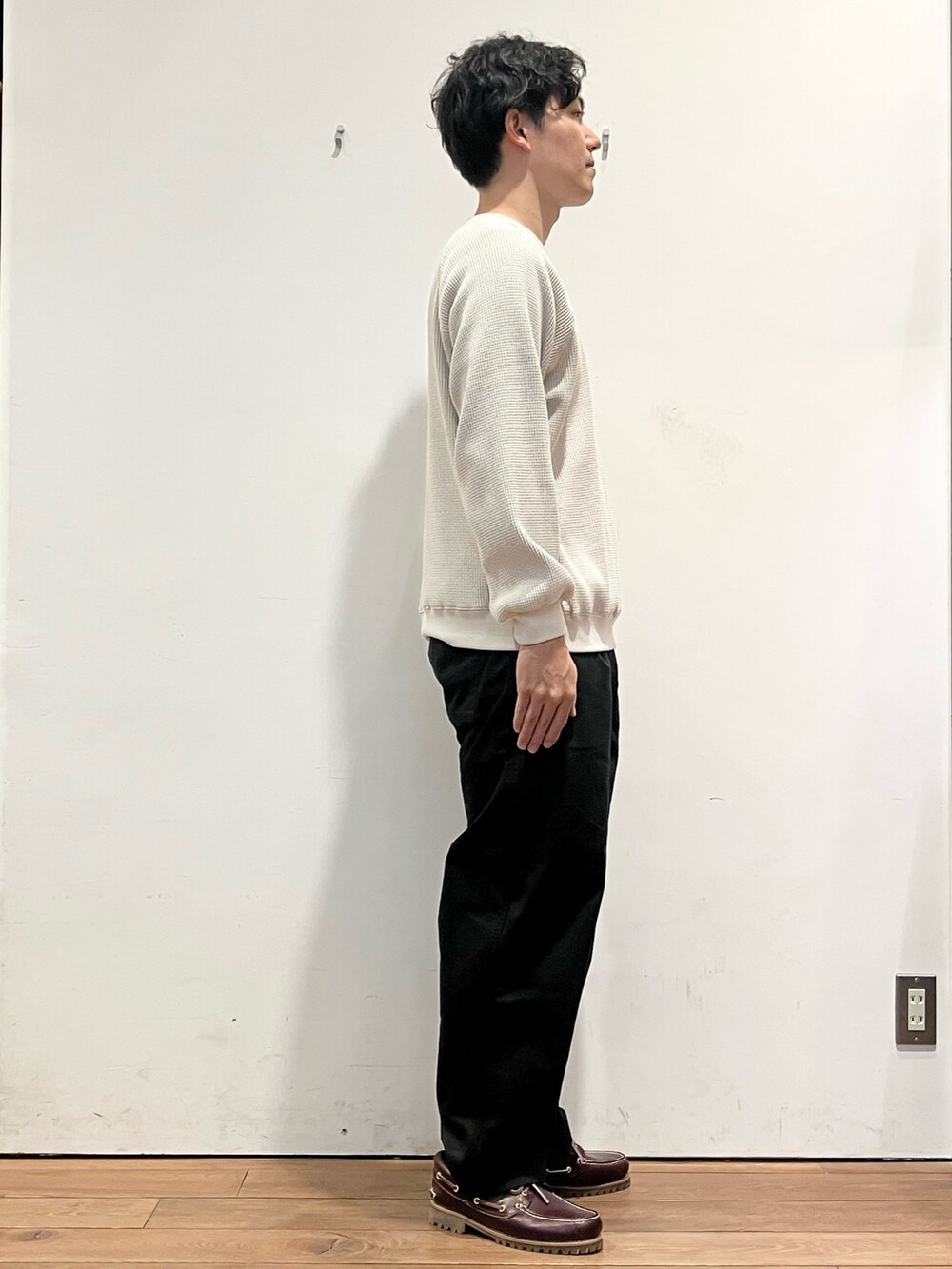 レッド系のダウンジャケット/コート、ベージュ系のTシャツ/カットソー、ブラック系のチノパンツを着用したメンズの秋コーディネートの6枚目の写真