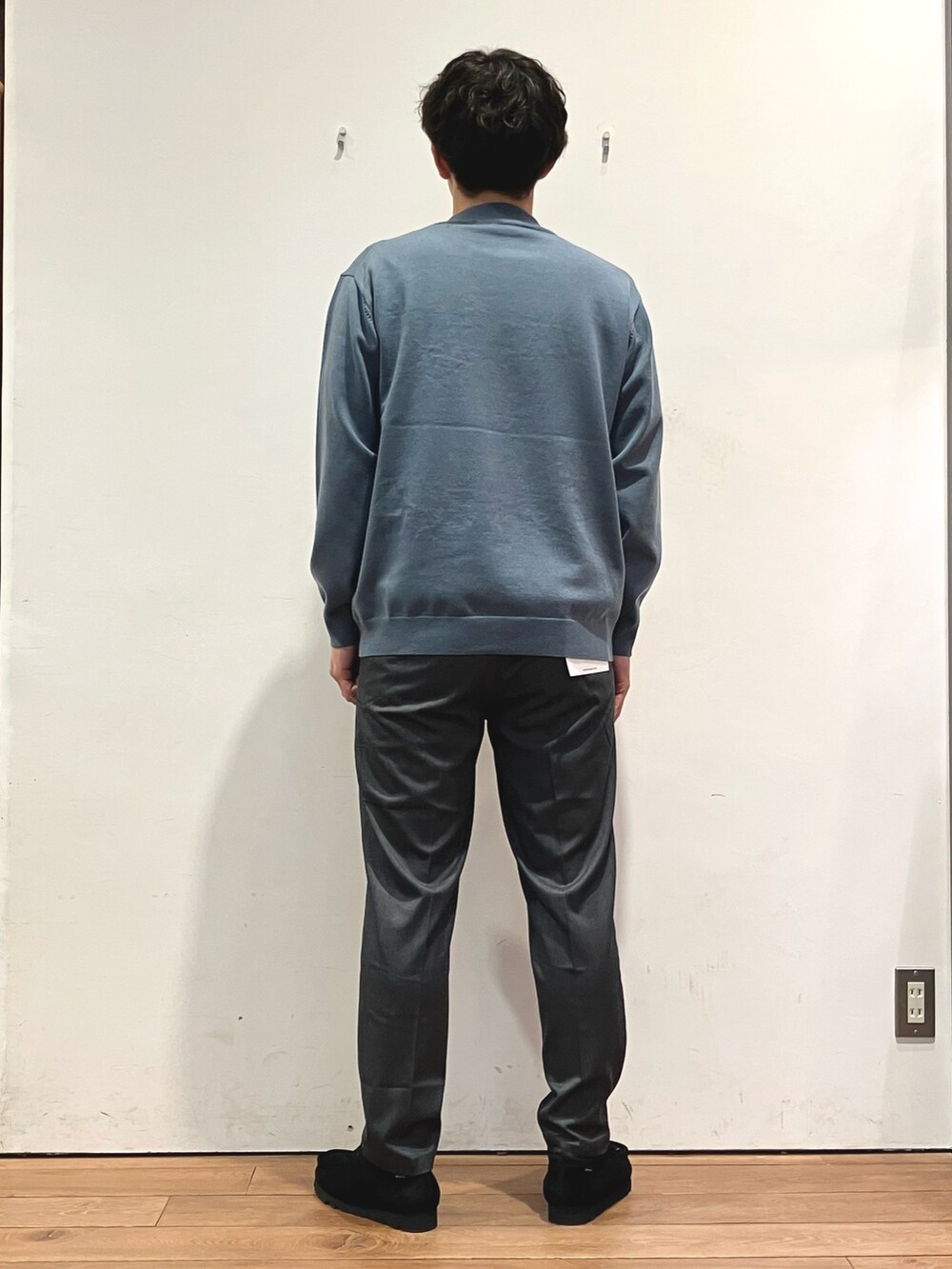 ブラック系のダウンジャケット/コート、ブルー系のニット/セーター、グレー系のその他パンツを着用したメンズの秋コーディネートの6枚目の写真