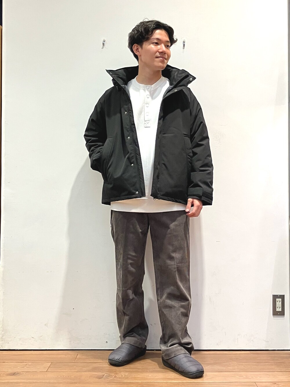 ブラック系のダウンジャケット/コート、ホワイト系のスウェット、ブラウン系のその他パンツを着用したメンズの秋コーディネートの4枚目の写真