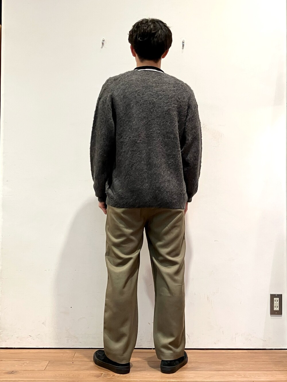 グレー系のカーディガン/ボレロ、ホワイト系のTシャツ/カットソー、グリーン系のパンツを着用したメンズの秋コーディネートの3枚目の写真