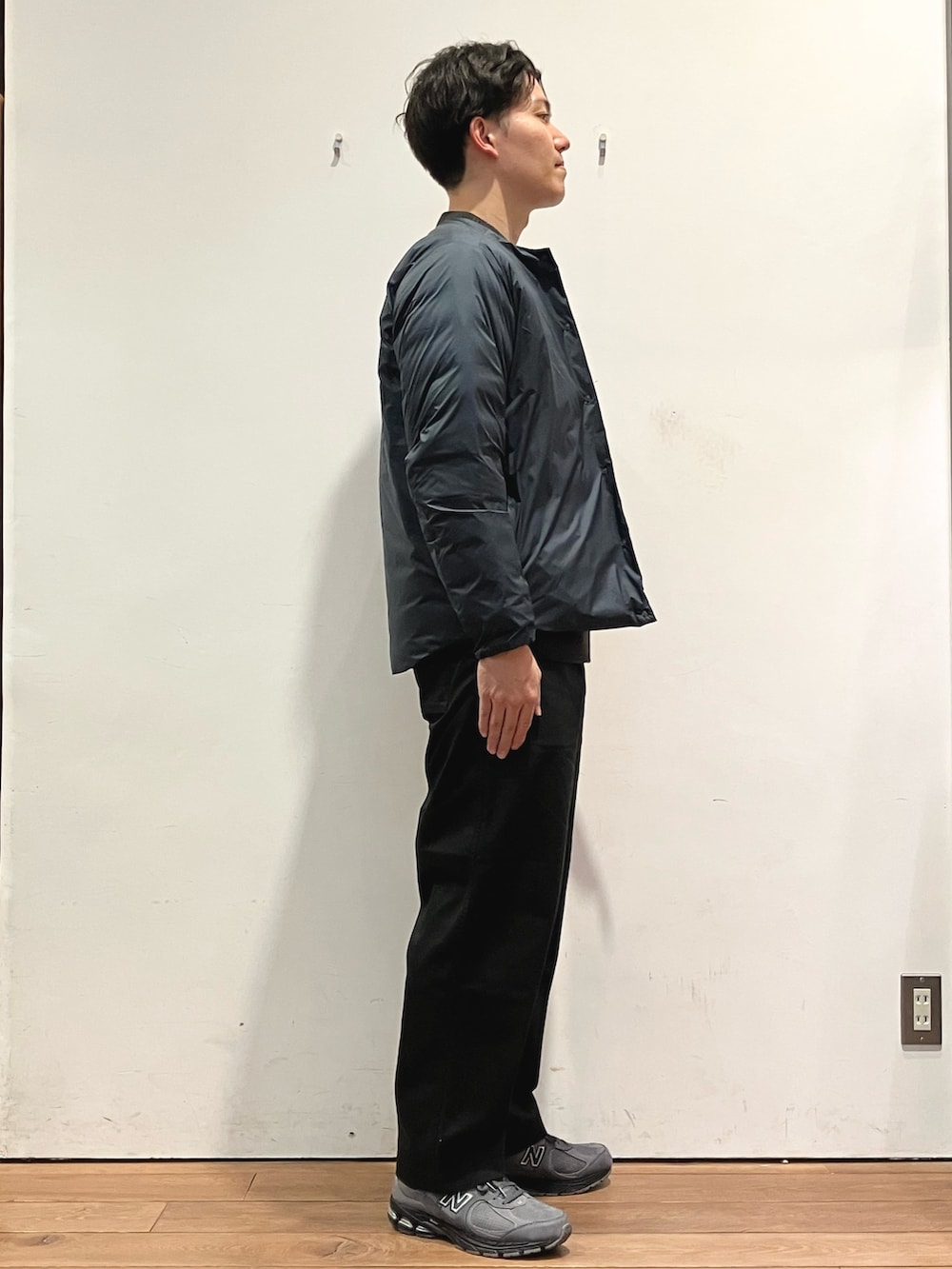 ブルー系のダウンジャケット/コート、ブラック系のチノパンツ、グレー系のニット/セーターを着用したメンズの秋コーディネートの2枚目の写真