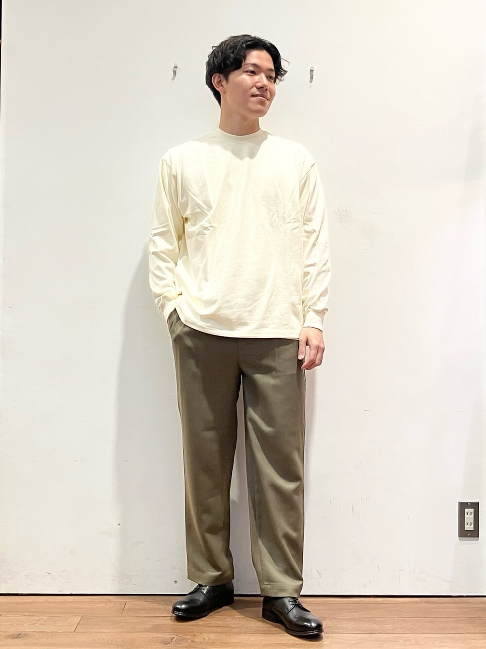 ブラウン系のカーディガン/ボレロ、ホワイト系のTシャツ/カットソー、ブラック系のドレスシューズを着用したメンズの秋コーディネートの4枚目の写真