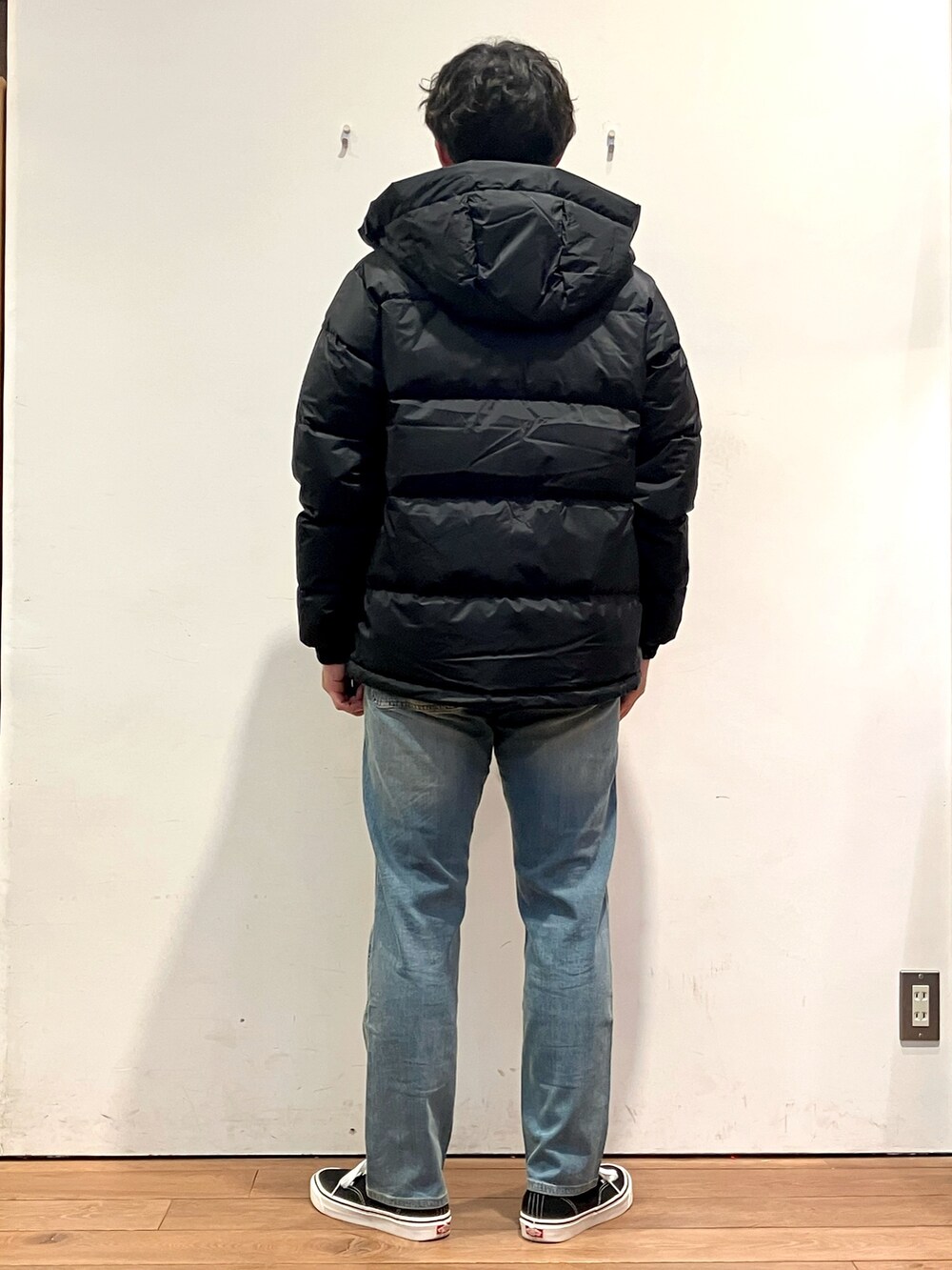 ブラック系のダウンジャケット/コート、ベージュ系のスウェット、ブルー系のその他パンツを着用したメンズの秋コーディネートの3枚目の写真