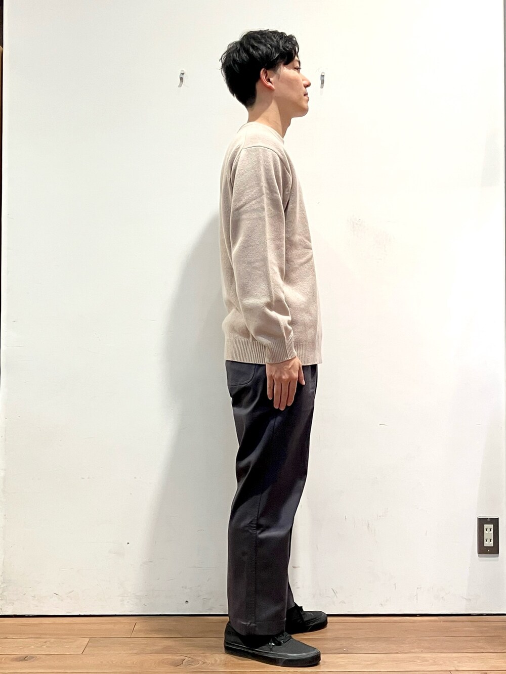 グリーン系のダウンジャケット/コート、ベージュ系のニット/セーター、グレー系のその他パンツを着用したメンズの秋コーディネートの5枚目の写真