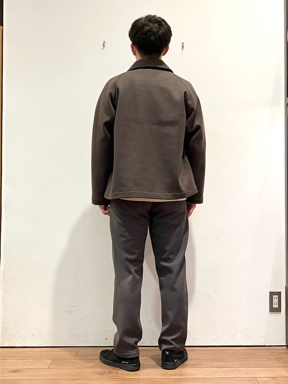 ブラウン系のその他アウター、ホワイト系のニット/セーター、ベージュ系のその他パンツを着用したメンズの冬コーディネートの4枚目の写真