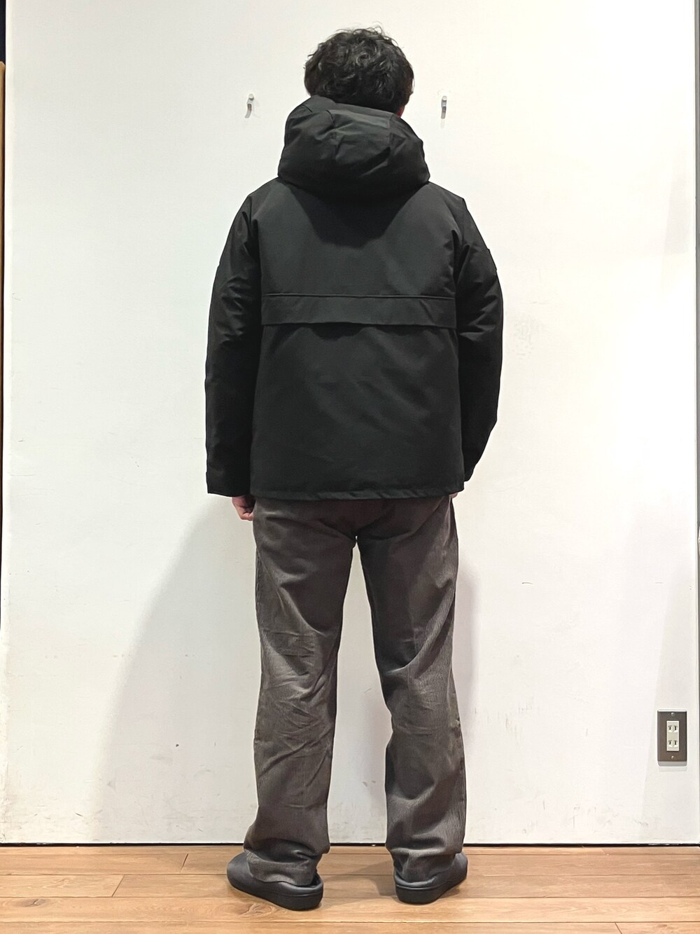 ブラック系のダウンジャケット/コート、ホワイト系のスウェット、ブラウン系のその他パンツを着用したメンズの秋コーディネートの3枚目の写真