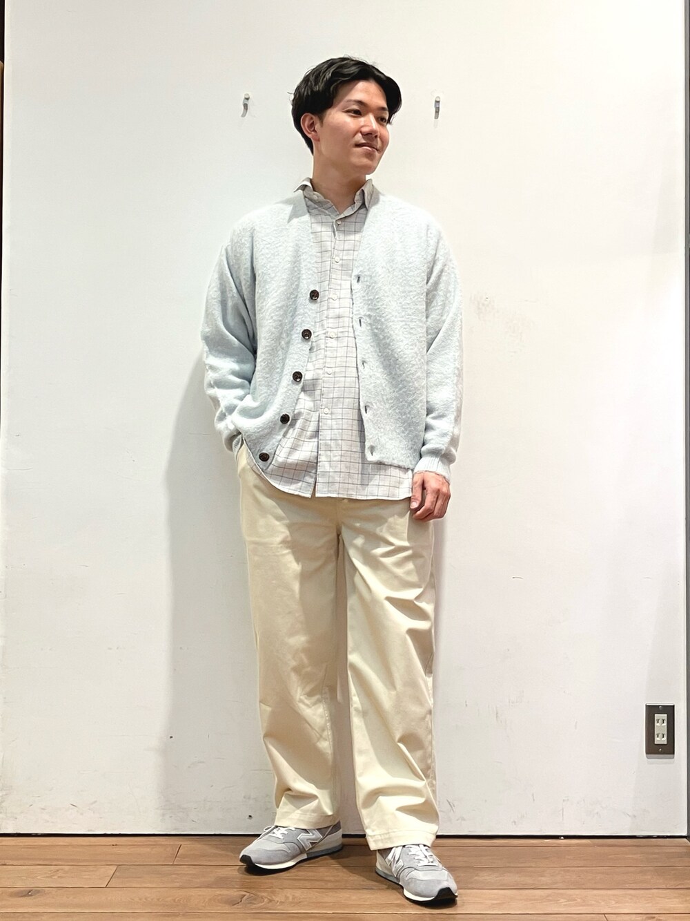 グリーン系のカーディガン/ボレロ、グレー系のシャツ/ブラウス、ホワイト系のチノパンツを着用したメンズの冬コーディネートの3枚目の写真