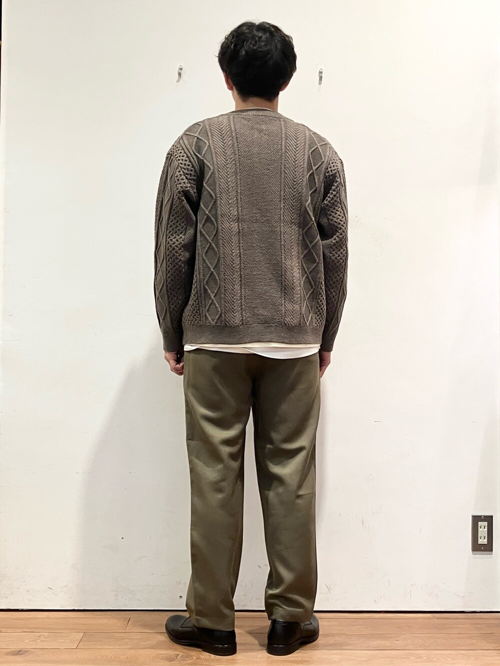 ブラウン系のカーディガン/ボレロ、ホワイト系のTシャツ/カットソー、ブラック系のドレスシューズを着用したメンズの秋コーディネートの3枚目の写真