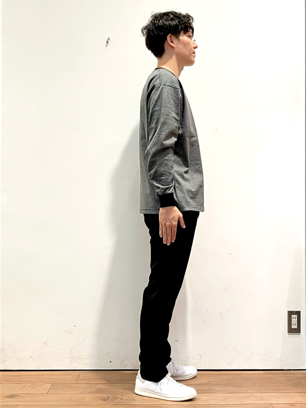 ブルー系のニット/セーター、ブラック系のTシャツ/カットソー、ホワイト系のスニーカーを着用したメンズの秋コーディネートの6枚目の写真