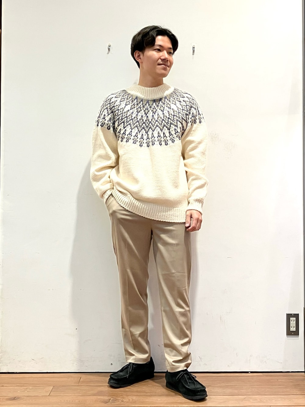 ブラック系のダウンジャケット/コート、ホワイト系のニット/セーター、ブラウン系のその他パンツを着用したメンズの冬コーディネートの4枚目の写真