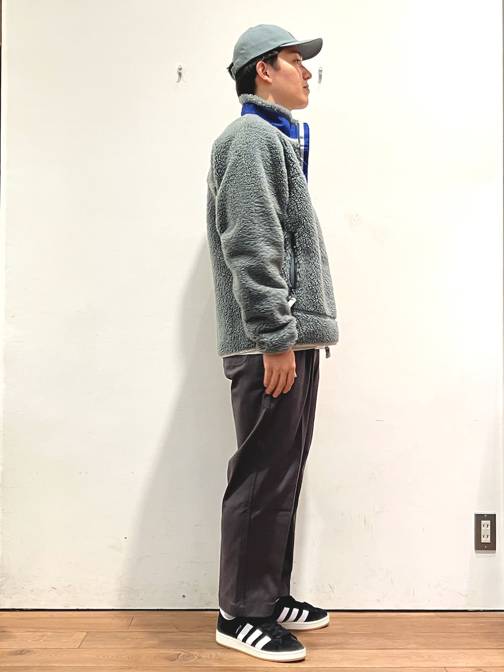 グリーン系のジャケット/アウター、ベージュ系のTシャツ/カットソー、ブラック系のスニーカーを着用したメンズの秋コーディネートの2枚目の写真