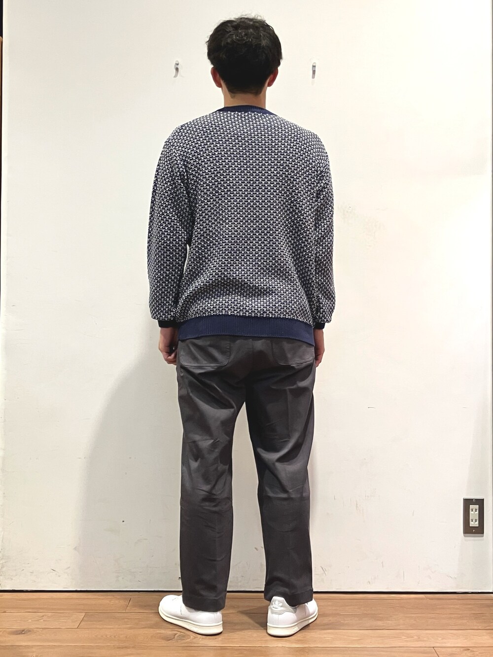 ブルー系のニット/セーター、グレー系のその他パンツ、ホワイト系のスニーカーを着用したメンズの秋コーディネートの3枚目の写真