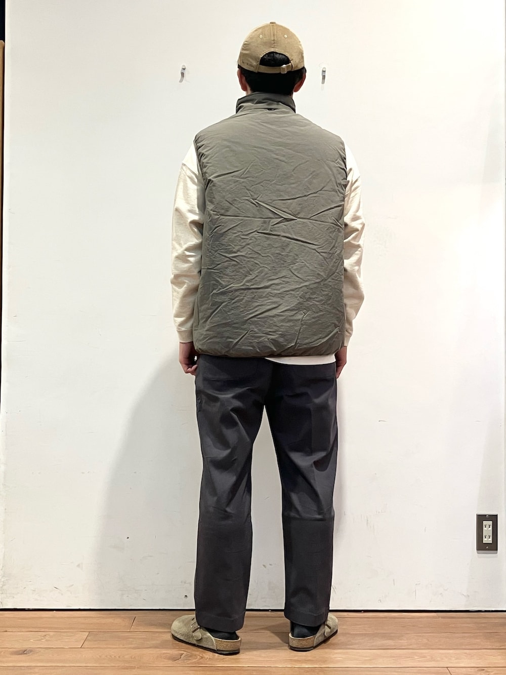 ベージュ系のダウンベスト、ベージュ系のスウェット、グレー系のその他パンツを着用したメンズの秋コーディネートの4枚目の写真