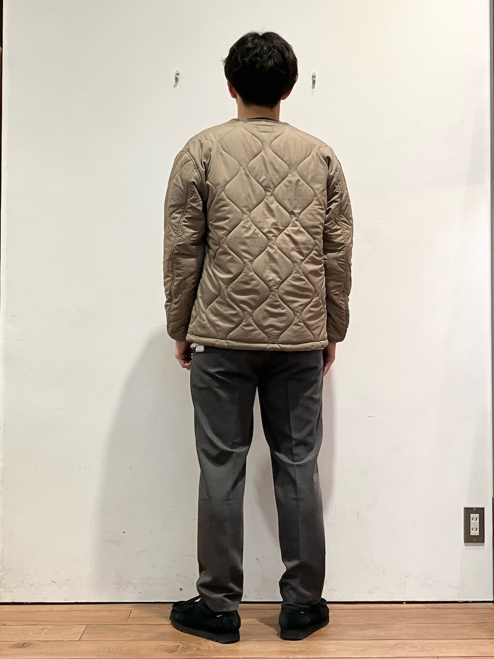 ブラウン系のダウンジャケット/コート、グレー系のその他パンツ、ブラウン系のニット/セーターを着用したメンズの冬コーディネートの4枚目の写真