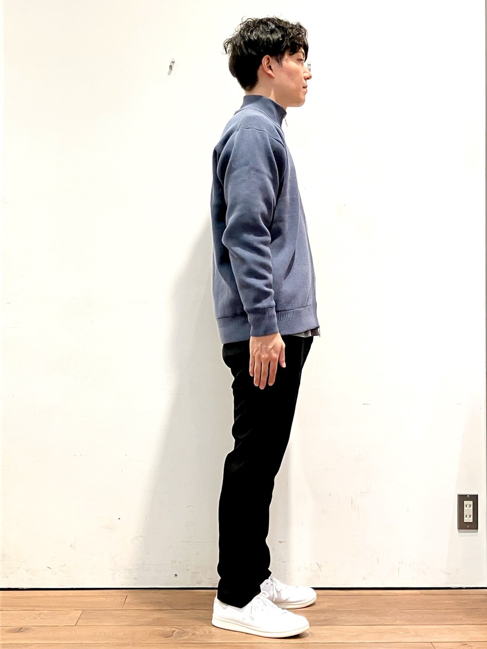 ブルー系のニット/セーター、ブラック系のTシャツ/カットソー、ホワイト系のスニーカーを着用したメンズの秋コーディネートの3枚目の写真