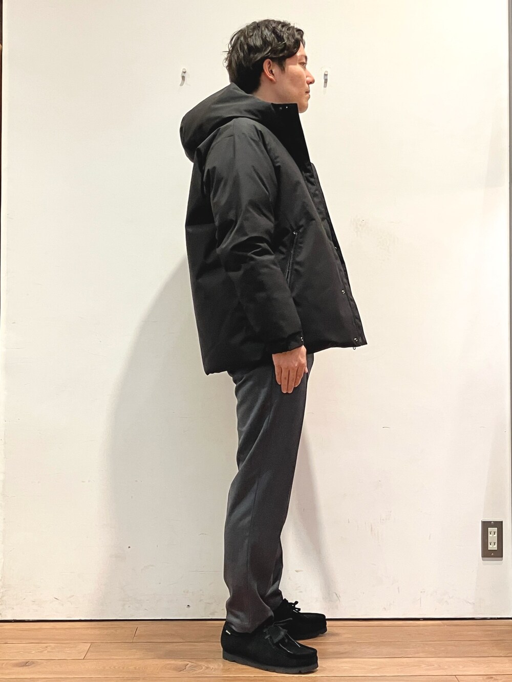 ブラック系のダウンジャケット/コート、ブルー系のニット/セーター、グレー系のその他パンツを着用したメンズの秋コーディネートの2枚目の写真