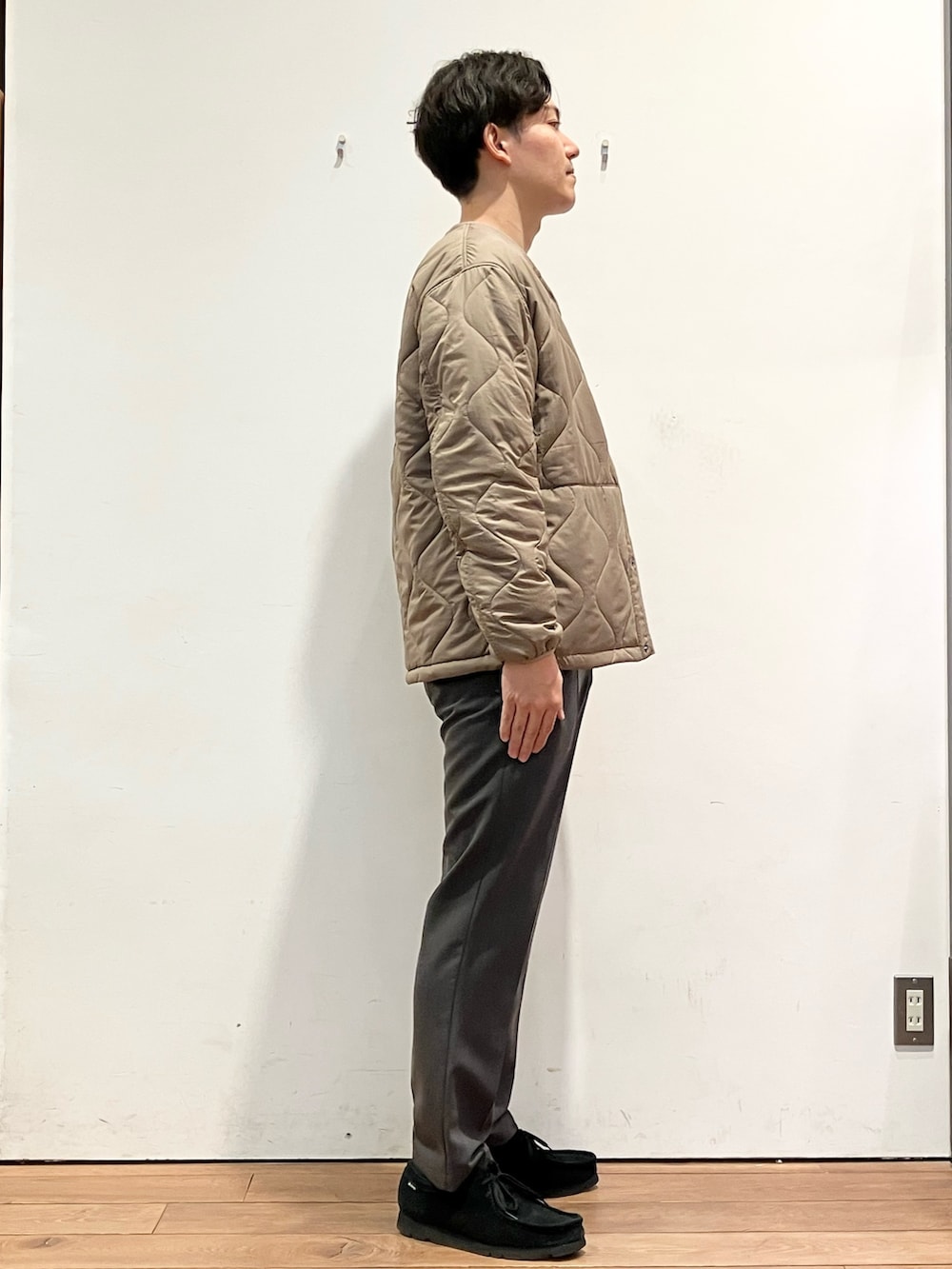 ブラウン系のダウンジャケット/コート、グレー系のその他パンツ、ブラウン系のニット/セーターを着用したメンズの冬コーディネートの3枚目の写真