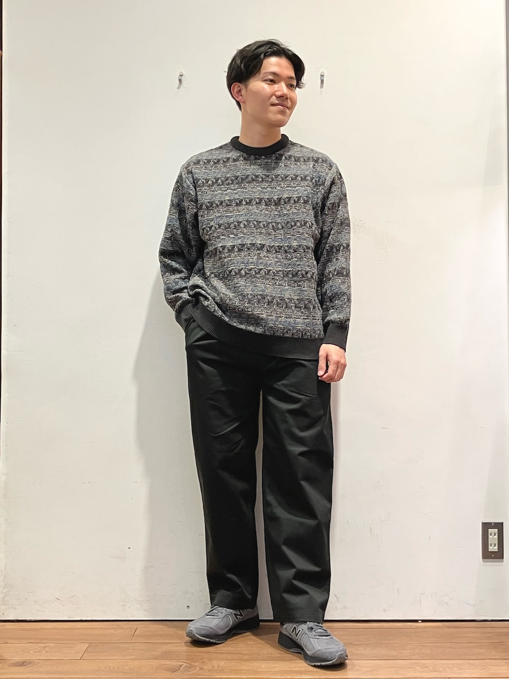 ブルー系のダウンジャケット/コート、ブラック系のチノパンツ、グレー系のニット/セーターを着用したメンズの秋コーディネートの4枚目の写真